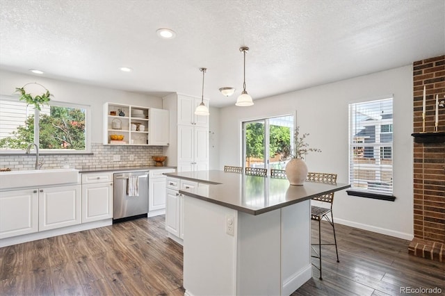 700 Prairie Ridge Rd, Highlands Ranch, CO 80126 - kitchen featuring dishwasher, dark wood-type flooring, decorative backsplash, white cabinets, and a kitchen island