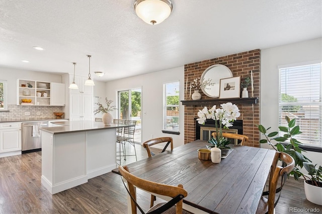 700 Prairie Ridge Rd, Highlands Ranch, CO 80126 - dining space featuring wood finished floors, a brick fireplace, a textured ceiling, and recessed lighting