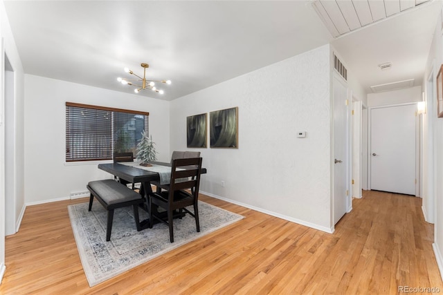 dining room with a chandelier, light hardwood / wood-style floors, and a baseboard heating unit