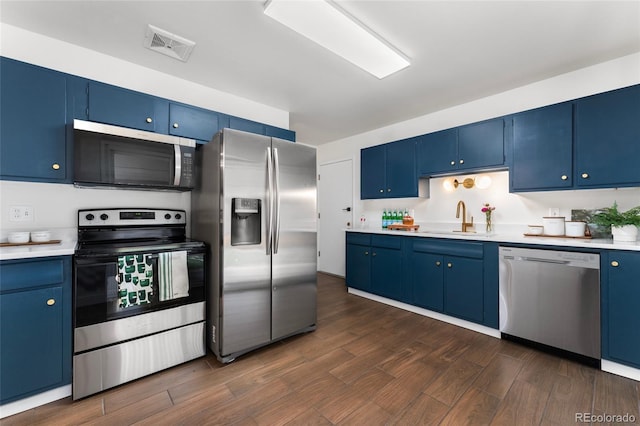 kitchen featuring blue cabinetry, stainless steel appliances, dark hardwood / wood-style floors, and sink