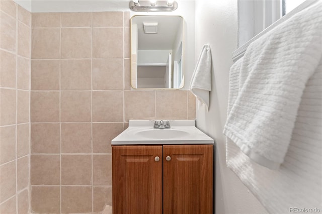 bathroom with vanity, tile walls, and tasteful backsplash