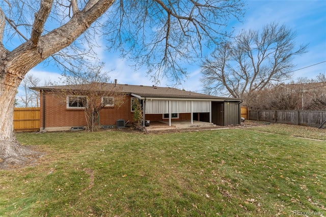 rear view of property with a lawn, central air condition unit, and a patio