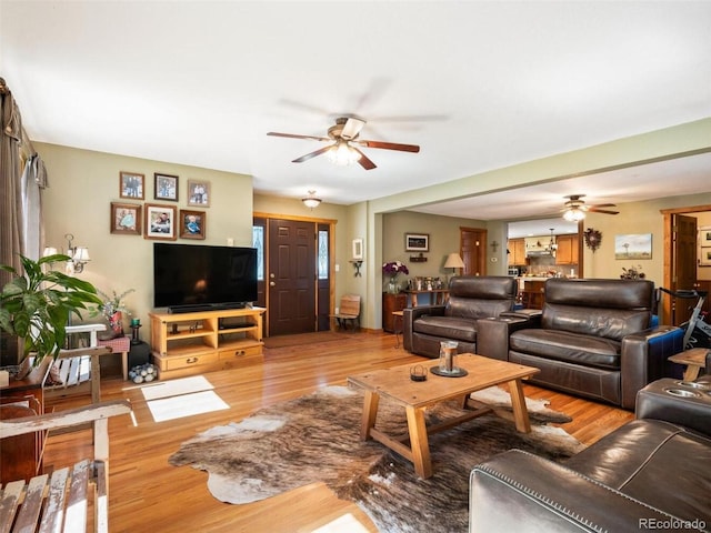 living room with ceiling fan and light hardwood / wood-style flooring