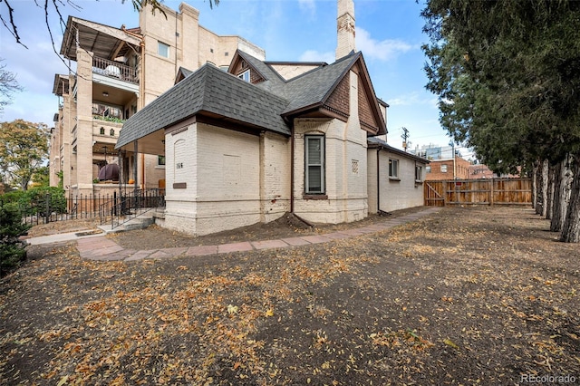 1516 Lafayette St, Denver, CO 80218 - rear view of property with brick siding, fence, a balcony, a shingled roof, and a chimney