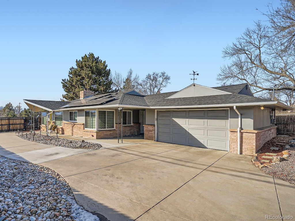 ranch-style home with a garage and solar panels