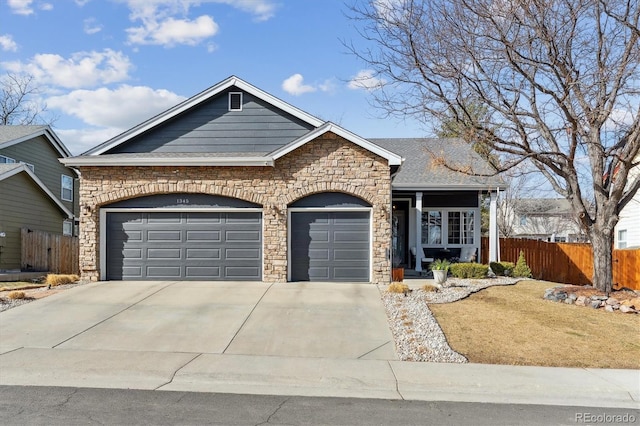 view of front of home with concrete driveway, a shingled roof, an attached garage, and fence