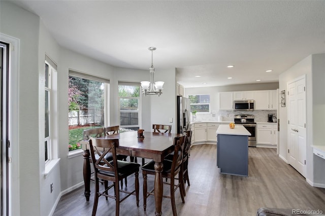 15432 Greenstone Cir, Parker, CO 80134 - dining room with light wood finished floors, a chandelier, and recessed lighting