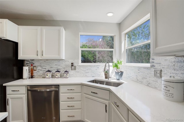 15432 Greenstone Cir, Parker, CO 80134 - kitchen with stainless steel dishwasher, tasteful backsplash, white cabinetry, light countertops, and freestanding refrigerator