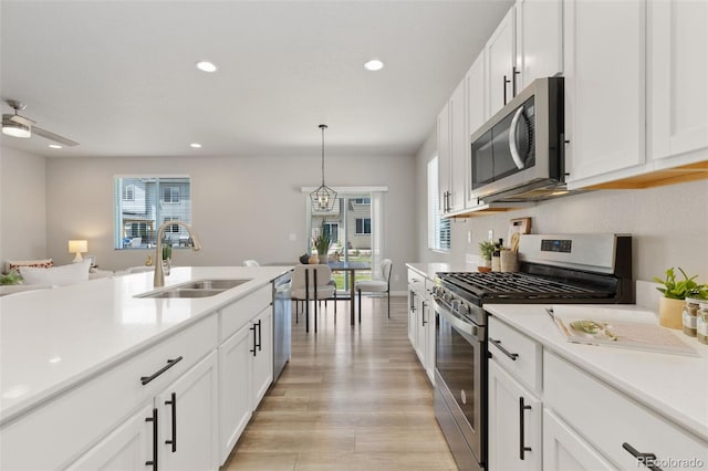 113 Marlowe Dr, Erie, CO 80516 - kitchen featuring stainless steel appliances, a sink, light countertops, recessed lighting, and white cabinets