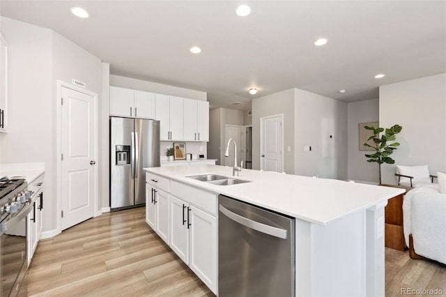 113 Marlowe Dr, Erie, CO 80516 - kitchen with stainless steel appliances, a sink, open floor plan, light wood-type flooring, and an island with sink