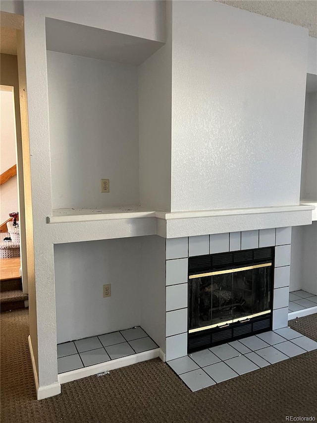 interior details with carpet and a tiled fireplace