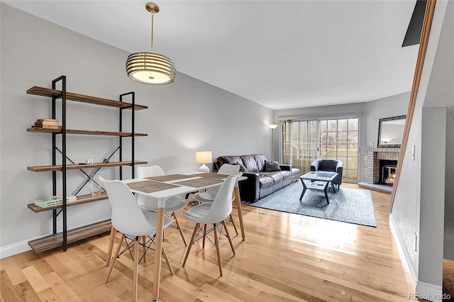 dining space with light hardwood / wood-style floors and a fireplace