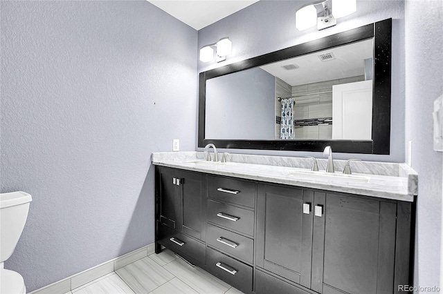 bathroom with walk in shower, vanity, and toilet