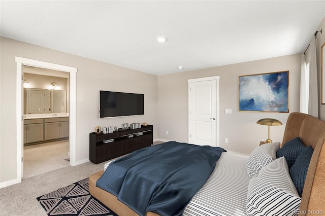 bedroom featuring connected bathroom and light carpet