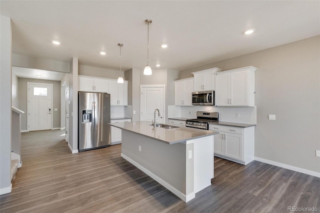 kitchen featuring stainless steel appliances, sink, a center island with sink, white cabinets, and dark hardwood / wood-style floors