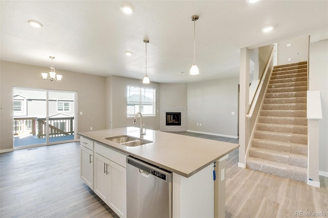 kitchen with a kitchen island with sink, sink, pendant lighting, dishwasher, and white cabinetry