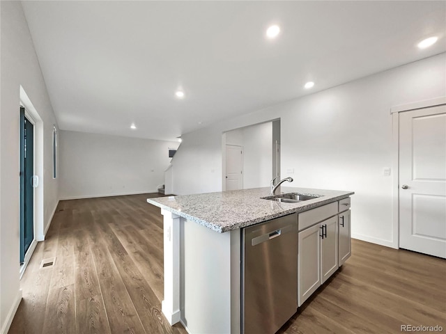 kitchen with an island with sink, stainless steel dishwasher, light stone countertops, and sink