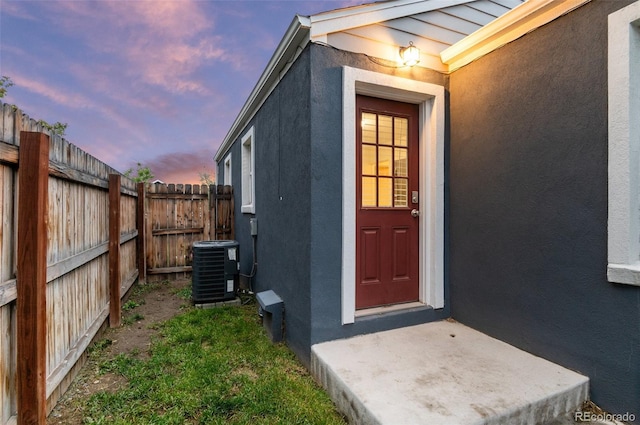 1414 W Nevada Pl, Denver, CO 80223 - exterior entry at dusk featuring stucco siding and central AC