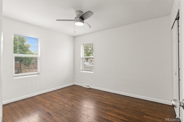 1414 W Nevada Pl, Denver, CO 80223 - unfurnished bedroom featuring multiple windows, baseboards, and dark wood-type flooring