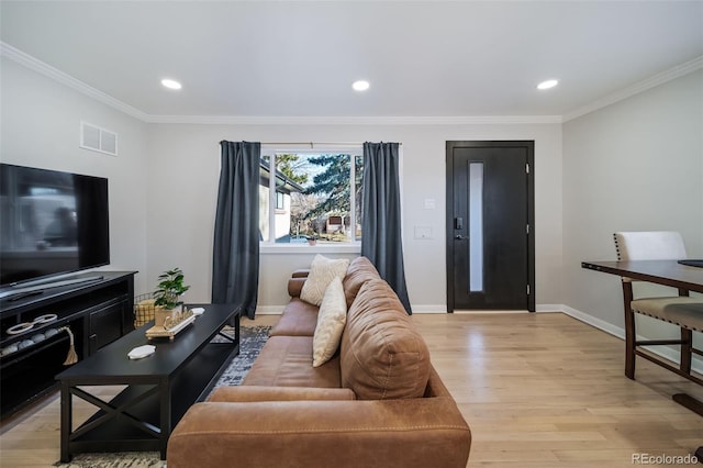 living room featuring light wood-type flooring and ornamental molding