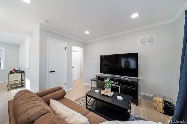 living room with crown molding and light hardwood / wood-style flooring