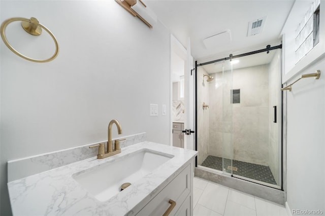 bathroom with tile patterned flooring, vanity, and a shower with door