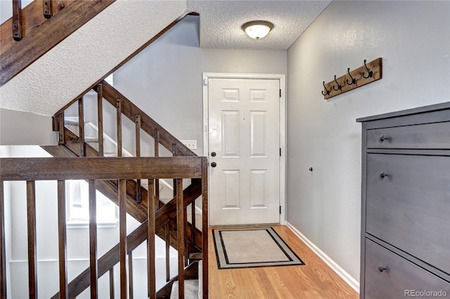 entryway featuring a textured ceiling and hardwood / wood-style flooring