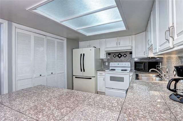 kitchen with white appliances, tasteful backsplash, white cabinetry, and sink