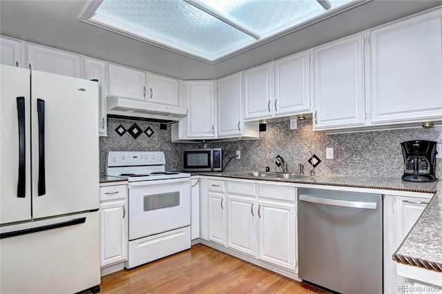 kitchen with appliances with stainless steel finishes, light wood-type flooring, decorative backsplash, white cabinets, and sink