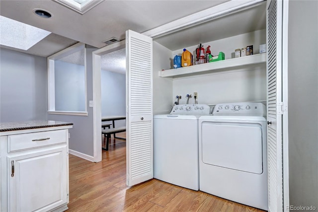 washroom with light hardwood / wood-style floors and washing machine and dryer