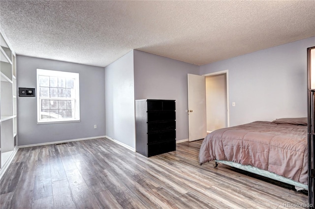 bedroom featuring a textured ceiling and wood-type flooring