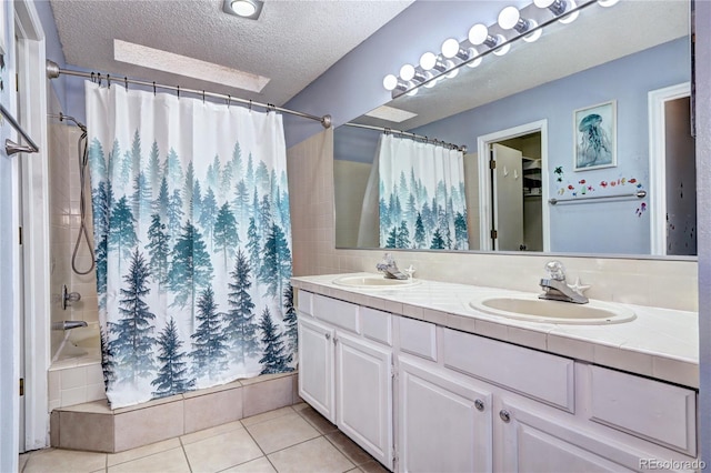 bathroom featuring a textured ceiling, vanity, shower / tub combo with curtain, and tile patterned floors