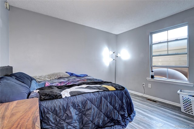 bedroom featuring wood-type flooring and a textured ceiling