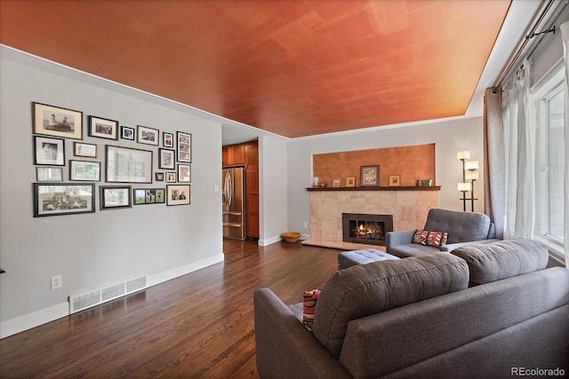 living room featuring dark hardwood / wood-style floors, plenty of natural light, and a fireplace