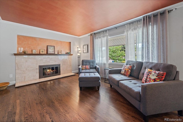 living room featuring ornamental molding, hardwood / wood-style floors, and a tile fireplace