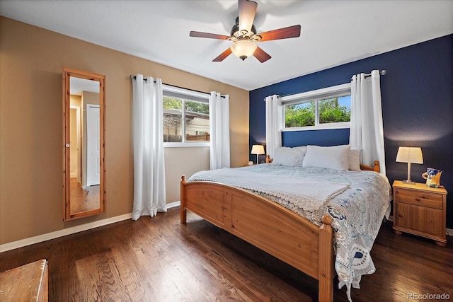 bedroom featuring ceiling fan, dark hardwood / wood-style flooring, and multiple windows