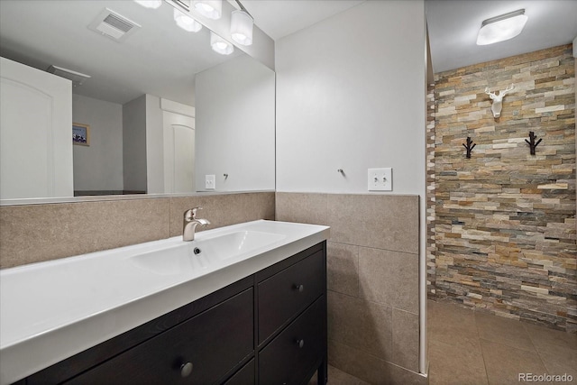 bathroom with vanity and tile walls