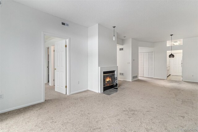 7453 Singing Hills Dr Unit E105, Boulder, CO 80301 - unfurnished living room with carpet, a fireplace with flush hearth, baseboards, and a textured ceiling