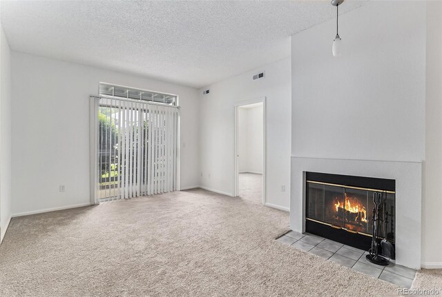 7453 Singing Hills Dr Unit E105, Boulder, CO 80301 - unfurnished living room featuring carpet flooring, a fireplace with flush hearth, a textured ceiling, and baseboards