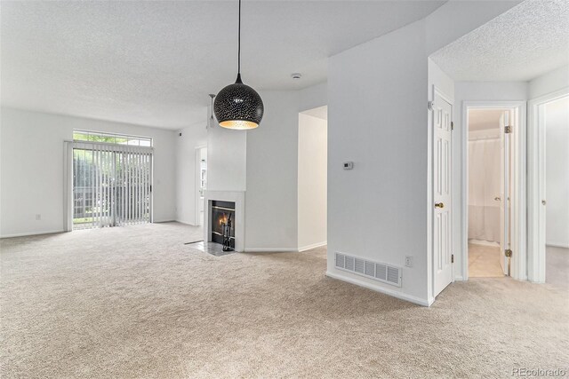 7453 Singing Hills Dr Unit E105, Boulder, CO 80301 - unfurnished living room with carpet flooring, a textured ceiling, a fireplace with flush hearth, and baseboards