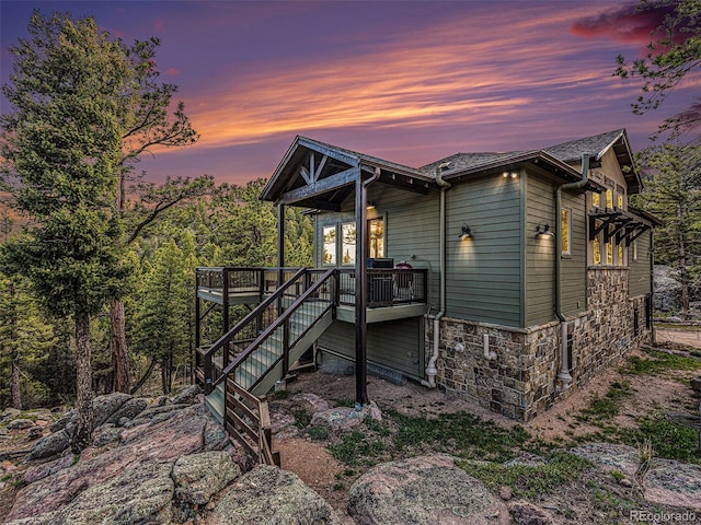 back house at dusk with a wooden deck