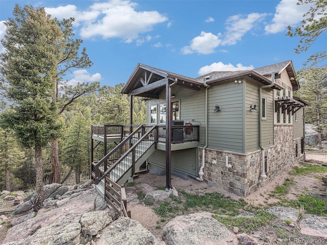 rear view of property featuring a wooden deck