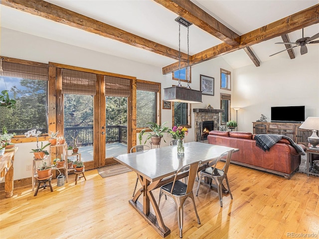 dining area featuring ceiling fan, vaulted ceiling with beams, and light wood-type flooring