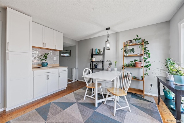 dining space featuring a textured ceiling and light wood-type flooring