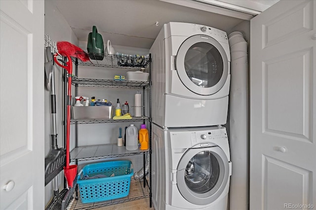 washroom featuring tile patterned flooring and stacked washing maching and dryer