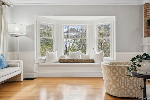 sitting room with crown molding, plenty of natural light, and light wood-type flooring