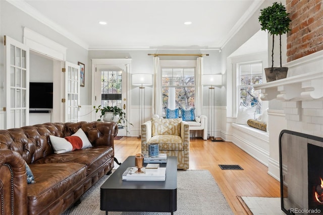 living room featuring hardwood / wood-style flooring, crown molding, and a fireplace