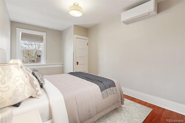 bedroom featuring hardwood / wood-style floors and a wall unit AC