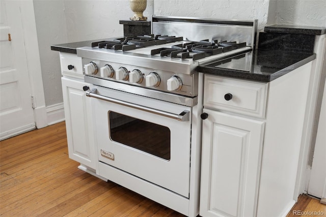 kitchen featuring white cabinetry, light hardwood / wood-style floors, and luxury range