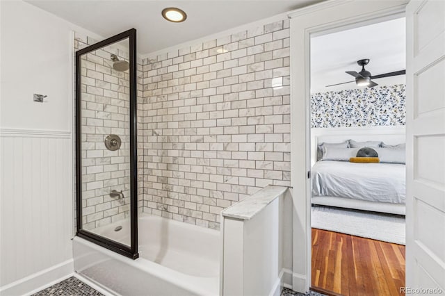 bathroom with wood-type flooring, enclosed tub / shower combo, and ceiling fan